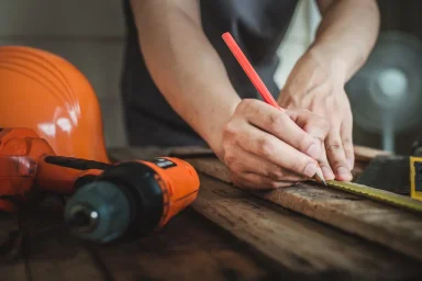 Snickare mäter med tumstock vid hantverksarbete